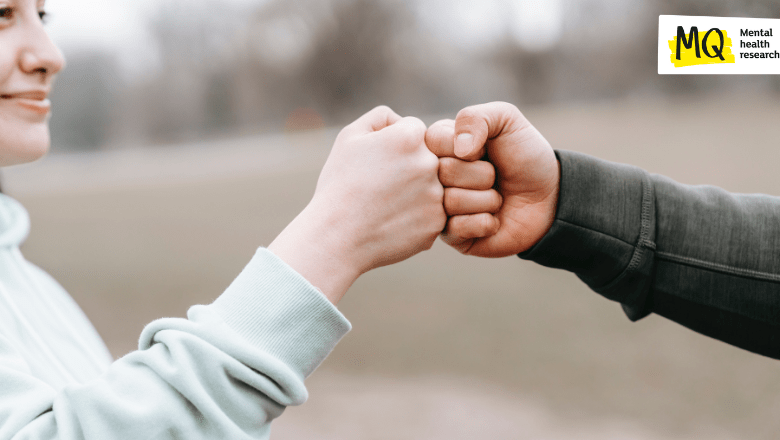 Two people are fist bumping