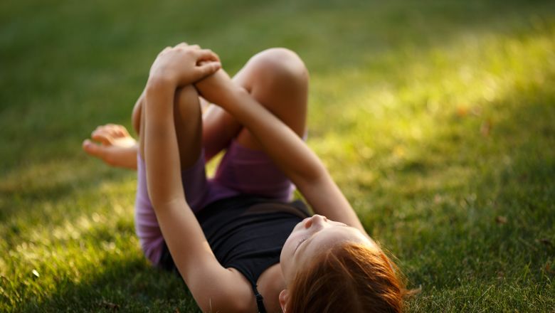 young girl laying on grass